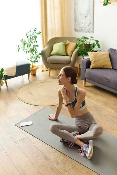 Dans un salon serein, une jeune femme souffrant d'anorexie s'engage dans son entraînement à domicile, mélangeant fitness, pleine conscience et autosoin.. — Photo de stock