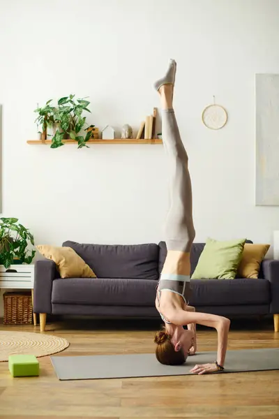 A young woman performs a yoga pose at home, emphasizing her commitment to fitness amidst personal challenges. — Stock Photo