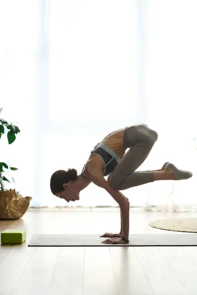 A young woman with anorexia engages in an intense yoga pose at home, reflecting determination and focus in her wellness journey. — Stock Photo