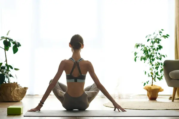 A young woman with anorexia engages in a mindful yoga practice at home, focusing on her wellness journey in a peaceful environment. — Stock Photo