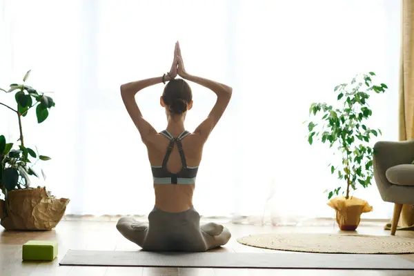 A young woman with anorexia engages in yoga at home, focusing on her mental and physical well-being in a serene environment. — Stock Photo