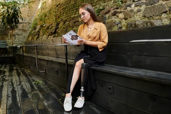 In einem charmanten Café liest eine junge Frau mit Beinprothese ein Menü und genießt einen Moment der Ruhe und Muße. — Stockfoto