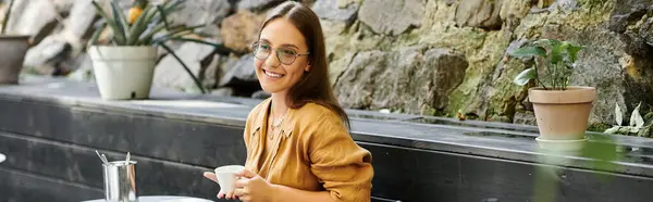 A young woman savors her coffee in a charming cafe, radiating confidence and positivity. — Stock Photo