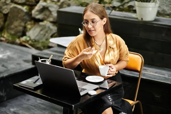 Em um ambiente de café vibrante, uma jovem mulher com uma perna protética bebe café enquanto se envolve em sua rotina diária. — Fotografia de Stock
