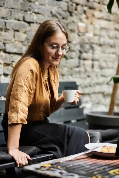 A young woman in a cafe sips her drink, presenting her confidence and daily lifestyle filled with joy. — Stock Photo