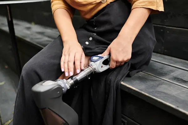 At a cozy cafe, a young woman showcases her artificial limb, embracing her daily lifestyle with grace and confidence. — Stock Photo