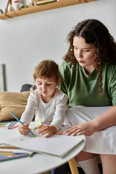 Una gioiosa madre plus size guida sua figlia in un progetto artistico in una giornata di sole al chiuso. — Foto stock