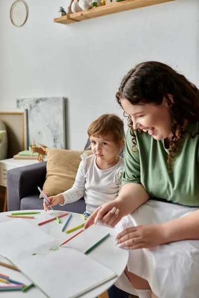 A plus size woman and her daughter enjoy a fun afternoon coloring together at home. — Stock Photo