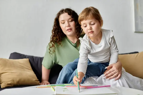 A loving mother encourages her daughter creativity while they relax indoors. — Stock Photo
