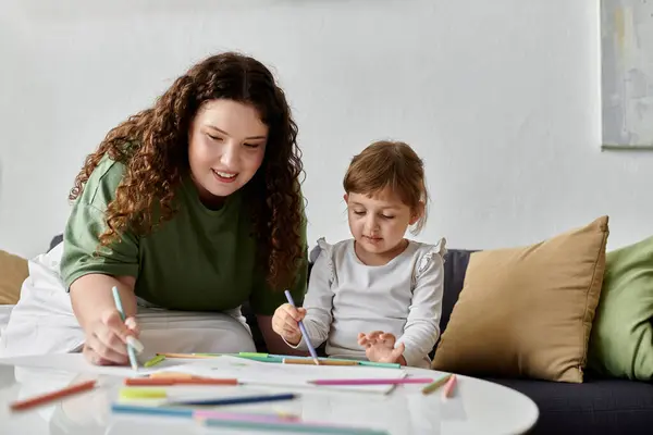Una donna plus size e sua figlia condividono un pomeriggio gioioso, creando opere d'arte colorate insieme. — Foto stock