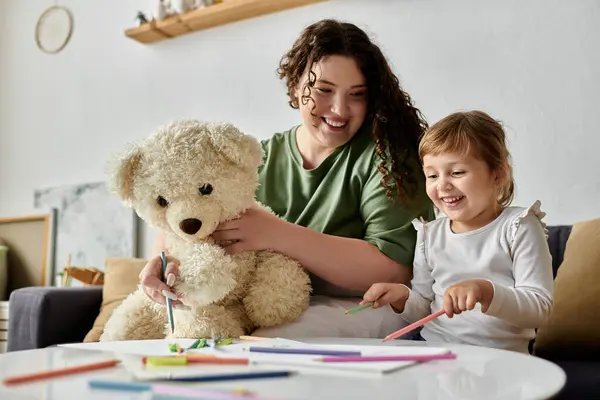 Una donna felice plus size e sua figlia condividono una divertente sessione d'arte con un orsacchiotto nelle vicinanze. — Foto stock