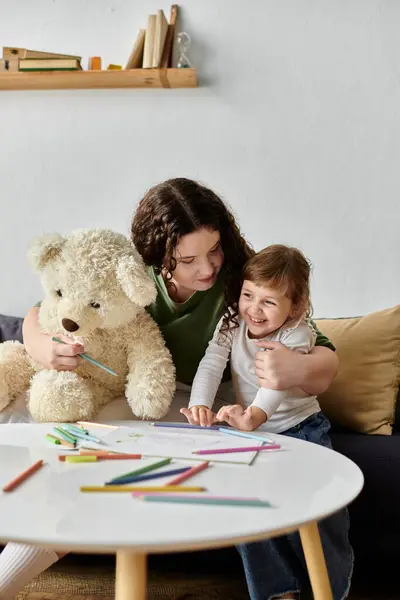 A cheerful mother and her daughter enjoy an arts and crafts session surrounded by colorful markers. — Stock Photo