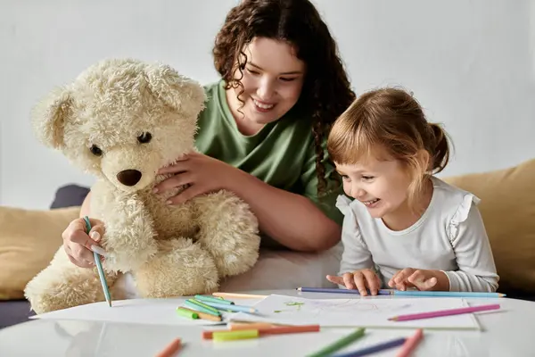 Eine entzückte Mutter und ihre Tochter bei einer fröhlichen Zeichenstunde mit bunten Buntstiften. — Stockfoto