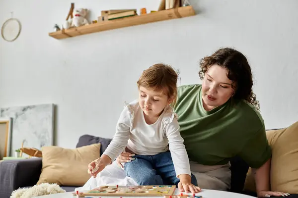 A loving plus size mother shares quality time with her daughter while playing a game indoors. — Stock Photo