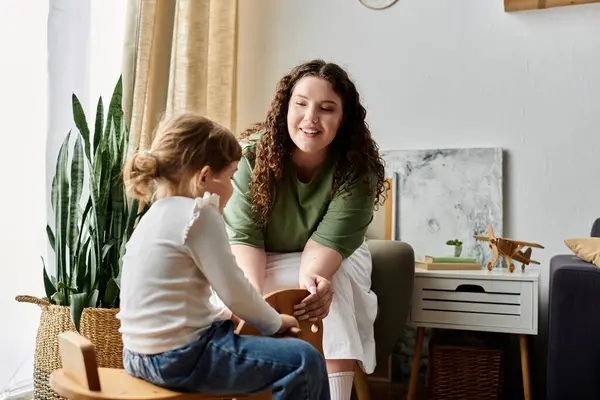A loving plus size mother shares a delightful interaction with her daughter at home. — Stock Photo