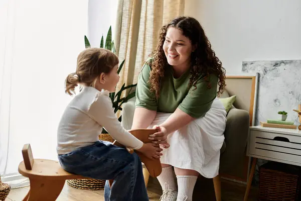 A joyful plus size mother engages with her daughter in a serene, cozy space. — Stock Photo