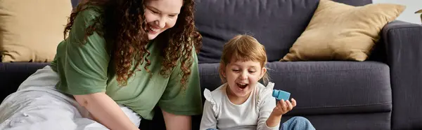 A mother and daughter share a joyful afternoon of laughter and play in their cozy living room. — Stock Photo