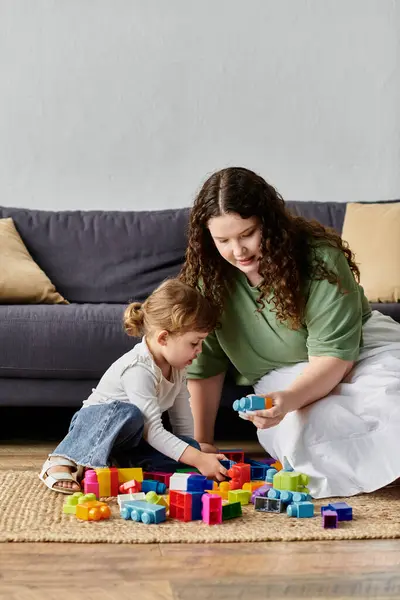 A mother and daughter create colorful block structures while enjoying quality time together. — Stock Photo