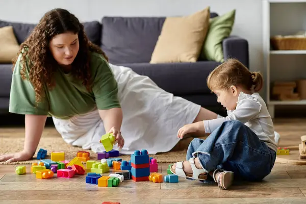 A mother and daughter happily engage in creative play as they build with bright blocks together. — Stock Photo