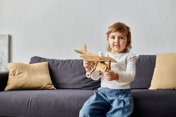 Little cute girl playing with her toy plane at home. — Stock Photo