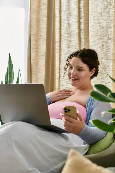 Une femme heureuse de taille plus en utilisant son ordinateur portable à la maison. — Photo de stock