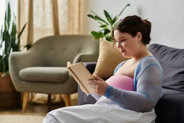 Stylish plus size woman in cozy homewear holding book in hands, at home. — Stock Photo