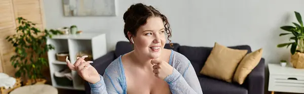 Joyous plus size woman with curly hair in cozy attire working at home. — Stock Photo