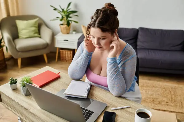 Lovely plus size woman with curly hair in cozy attire working at home. — Stock Photo