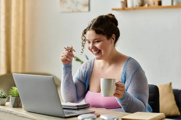 Feliz mulher plus size com cabelo encaracolado em trajes aconchegantes trabalhando em casa. — Fotografia de Stock