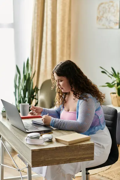 Devoted plus size woman with curly hair in cozy attire working at home. — Stock Photo