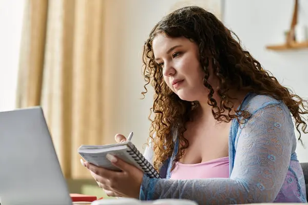 Dedicated plus size woman with curly hair in cozy attire working at home. — Stock Photo