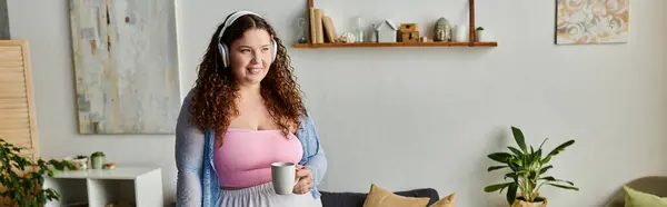 Delighted woman with curly hair and comfy vibrant attire at home. — Stock Photo