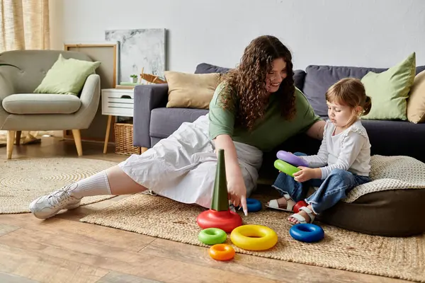 A mother and daughter enjoy colorful toys on a cozy floor in their inviting living room. — Stock Photo