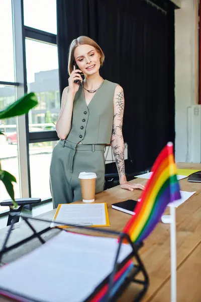 Une femme professionnelle parle au téléphone tout en restant debout dans un environnement de bureau dynamique. — Photo de stock