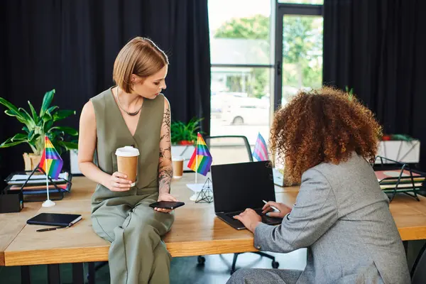 Two colleagues engage in a discussion while embracing a colorful workspace focused on unity. — Stock Photo