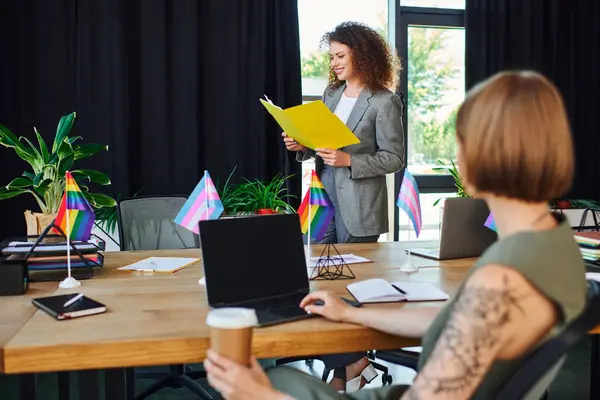 In a colorful office, coworkers collaborate enthusiastically to support their community. — Stock Photo