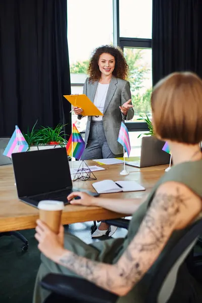 Coworkers celebrate diversity with flags while discussing important workplace initiatives. — Stock Photo