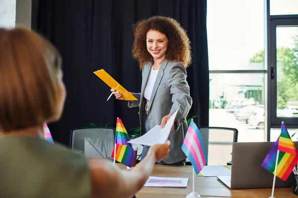 Two colleagues engage in a vibrant exchange during an office meeting filled with pride. — Stock Photo