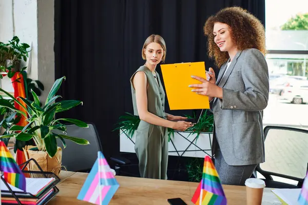 Two coworkers happily engage in a collaborative moment, sharing ideas and expressions of support. — Stock Photo