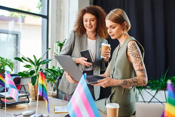 Two coworkers collaborate on a project, celebrating their vibrant identities at work. — Stock Photo