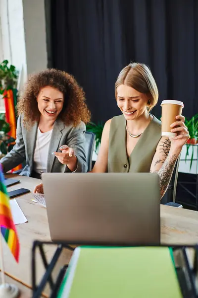 Two colleagues share laughter and ideas while working in a vibrant, welcoming office. — Stock Photo