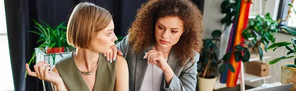 Two coworkers engage in a meaningful conversation surrounded by plants and colorful decor. — Stock Photo
