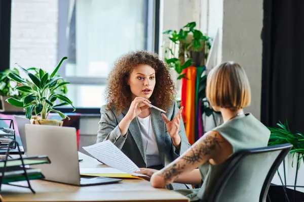 Two coworkers passionately exchange ideas in a welcoming office, highlighting their teamwork. — Stock Photo