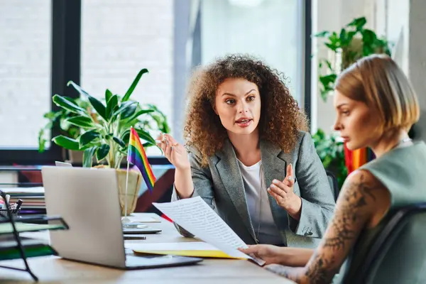 Zwei Mitarbeiter diskutieren ein Projekt, feiern Inklusivität und Kreativität am Arbeitsplatz. — Stockfoto