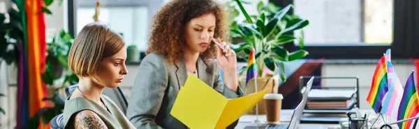 In a bright office, coworkers engage in a thoughtful discussion, representing the LGBT community. — Stock Photo