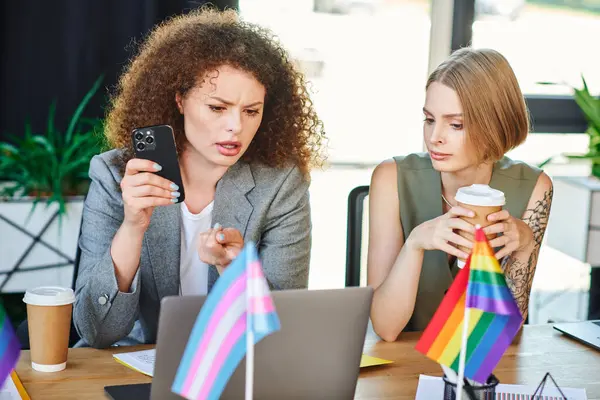 Two coworkers share a passionate conversation over coffee in a lively office, embracing diversity. — Stock Photo