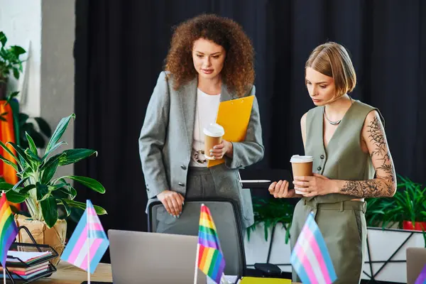 Two coworkers discuss productively amid vibrant decor symbolizing inclusivity. — Stock Photo