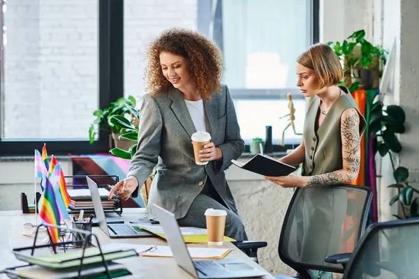 Two coworkers engage in a creative discussion while promoting LGBT inclusivity in the office. — Stock Photo