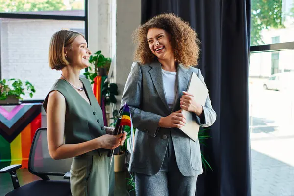 Two colleagues share a joyful moment, promoting inclusivity in their workspace. — Stock Photo