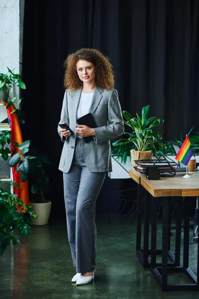 A woman posing enthusiastically, celebrating diversity in a vibrant office setting. — Stock Photo